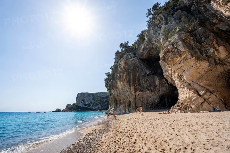 Sandy beach beach and steep cliffs with caves at Cala Luna, Golfo di Orosei, Baunei, Sardinia, Italy