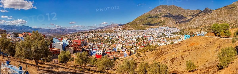 Colourful houses on a mountainside under a clear blue sky, Morocco, Chefchaouen, panorama