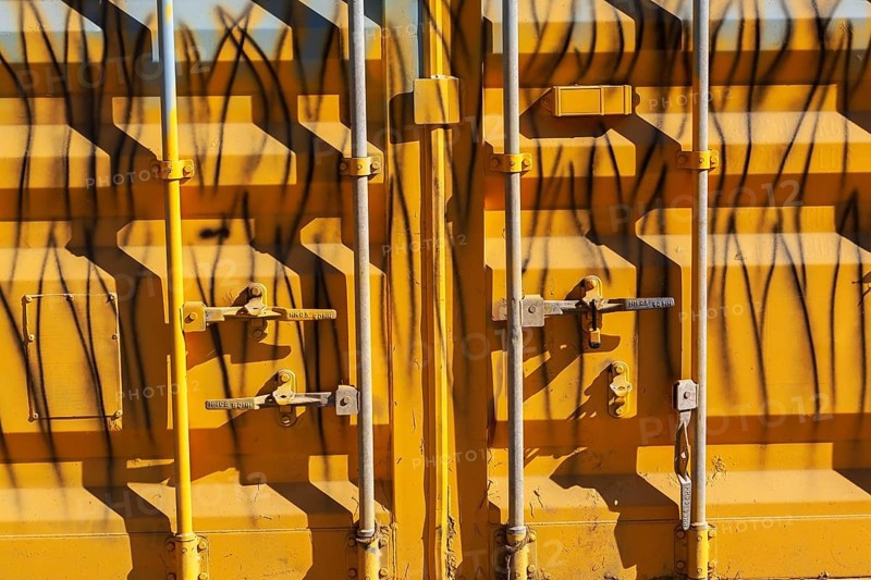 Close-up of locked doors on yellow painted metal boxed shaped shipping container, Quebec, Canada