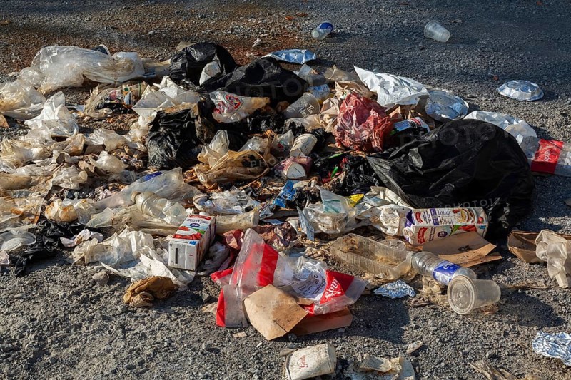 Recyclable plastic, paper and cardboard items discarded on the ground in public park, Quebec, Canada