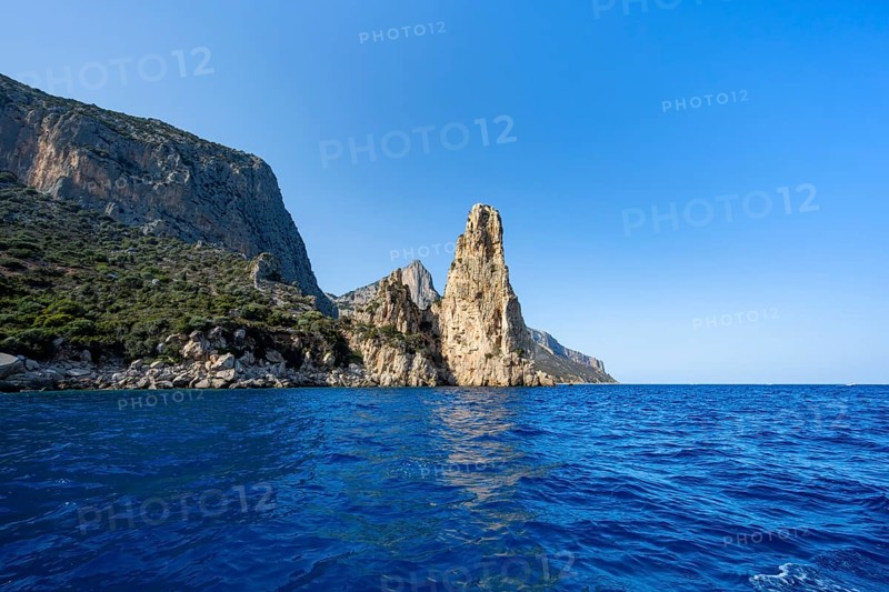 Picturesque rocky coast, cliffs with Pedra Longa pinnacle in the evening light, blue sea, Golfo di Orosei, Baunei, Sardinia, Italy