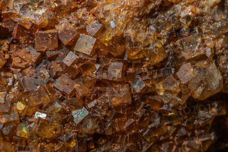 Bright, square crystals are visible on a piece of rock. The light underlines their structure and color. This mineral formation is fascinating and fascinating