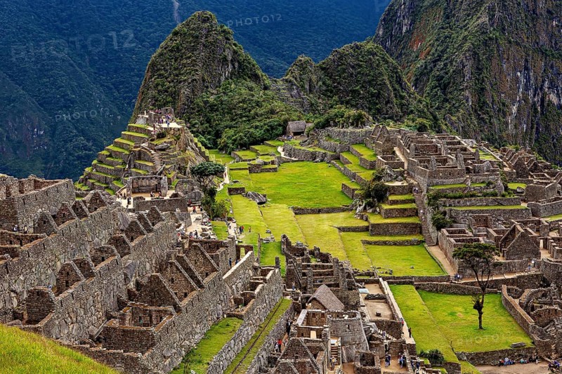 Ancient stone ruins and green terraces against a mountain backdrop, The ruins of the Inca city of Machu Picchu in Peru