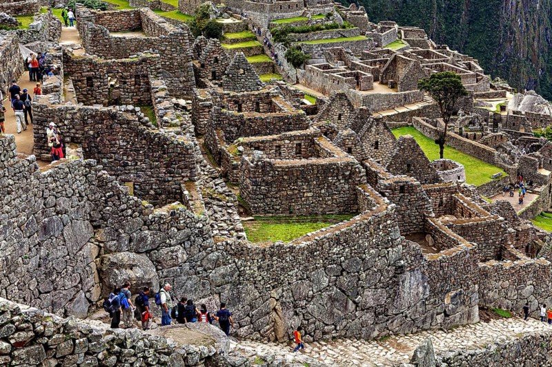 Tourists explore the well-preserved stone ruins of Machu Picchu, the ruins of the Inca city of Machu Picchu in Peru