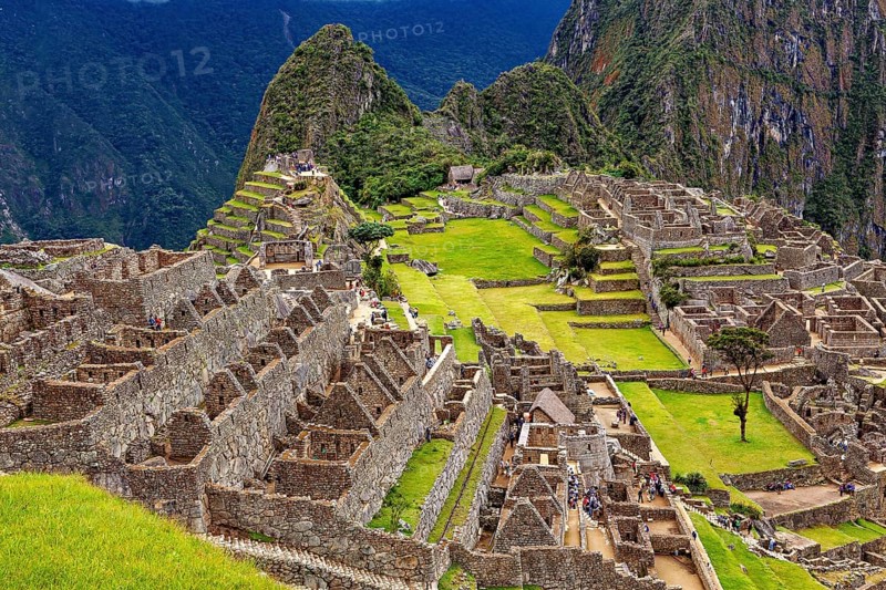Extensive ruins and terraces in an ancient city nestled in mountains, the ruins of the Inca city of Machu Picchu in Peru