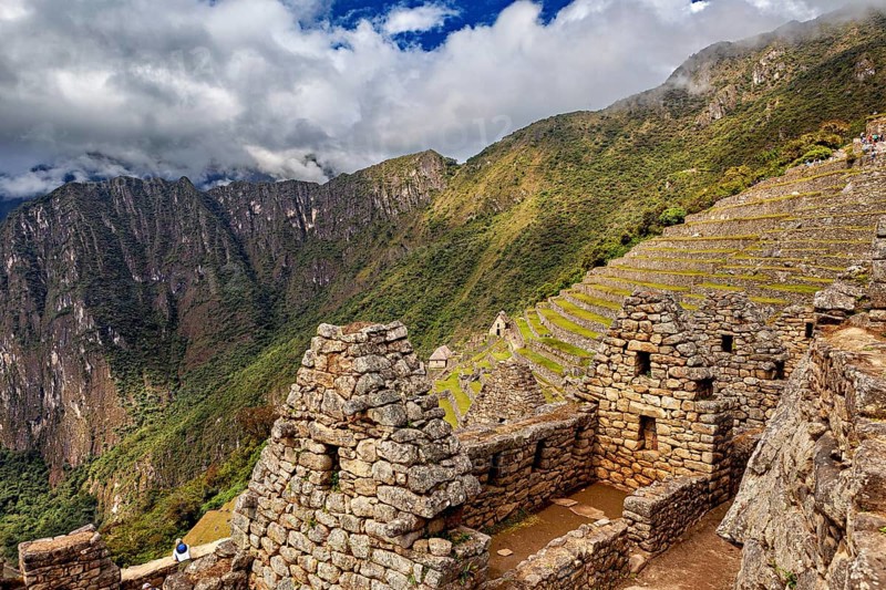 Old stone buildings with terraces in a mountainous landscape under clouds, The ruins of the Inca city of Machu Picchu in Peru