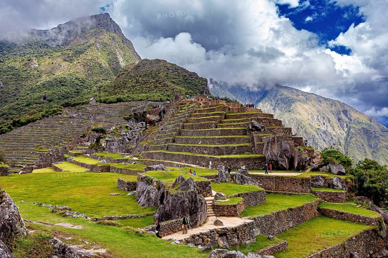 Terraced Inca landscape against dramatic clouds and mountains in Machu Picchu, The ruins of the Inca city of Machu Picchu in Peru