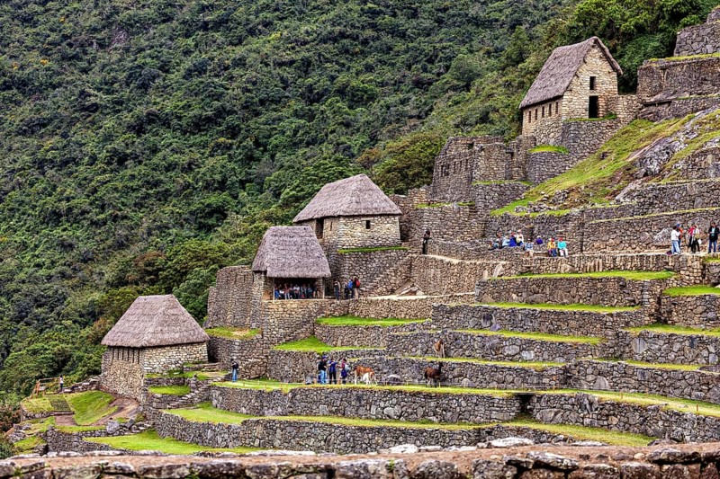 Traditional Inca huts and terraces on a green mountainside near Machu Picchu, The ruins of the Inca city of Machu Picchu in Peru