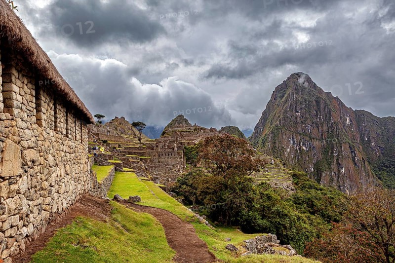 Stone houses and ruins of Machu Picchu with views of cloudy mountains, The ruins of the Inca city of Machu Picchu in Peru
