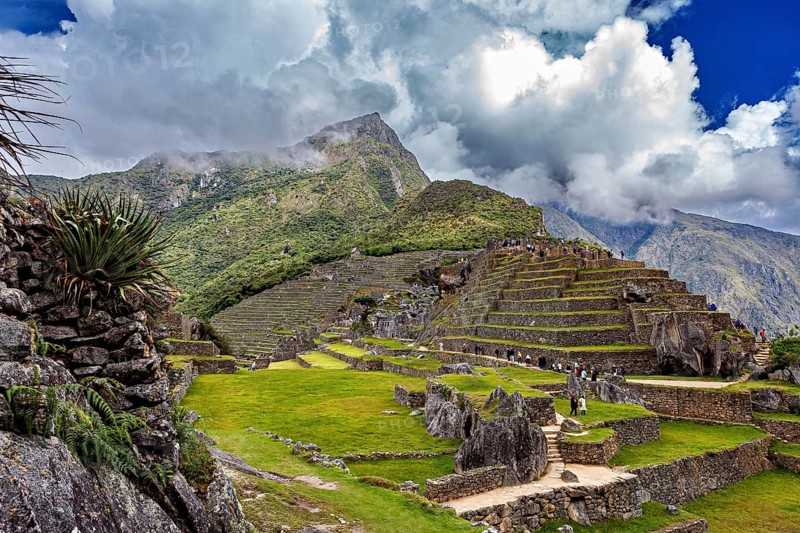 Inca terrace landscape under dramatic sky with clouds and mountain peaks near Machu Picchu, The ruins of the Inca city of Machu Picchu in Peru