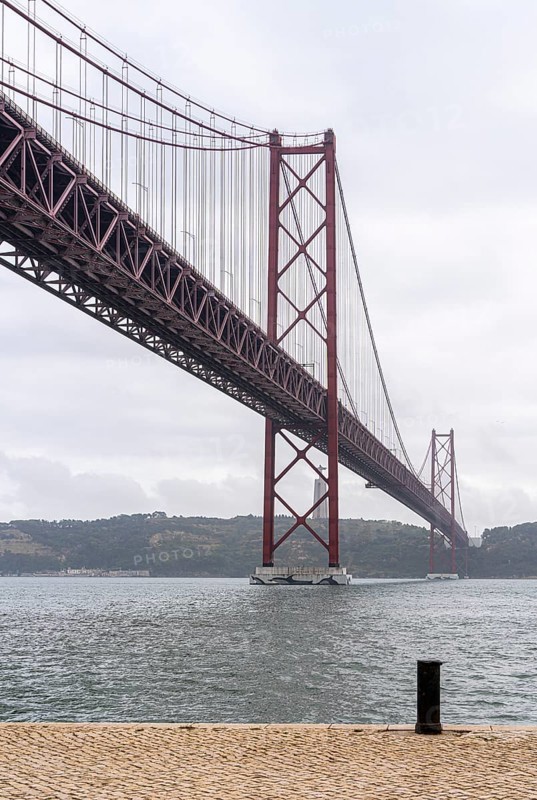 The Ponte 25 de Abril, 3.2 km long bridge in Portugal with a 2278 meter long suspension bridge across the Tagus, cloudy and rainy weather, third-longest suspension bridge with combined road and rail traffic, Lisbon, Portugal
