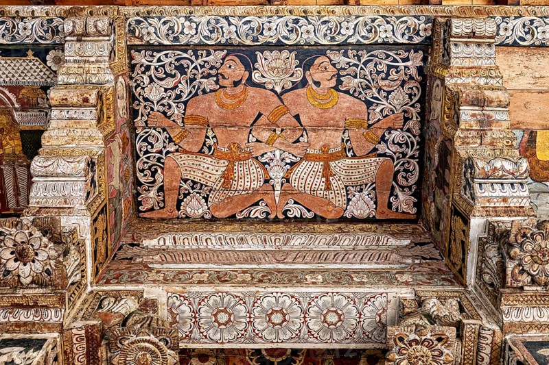 Ornate wall painting with two symmetrical warrior figures in a traditional temple, the decoration inside the Temple of the Tooth of Kandy Sri Lanka