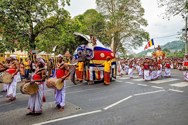 Parade with drummers and an elephant surrounded by celebratory spectators, The Perahera Parade in Kandy Sri Lanka