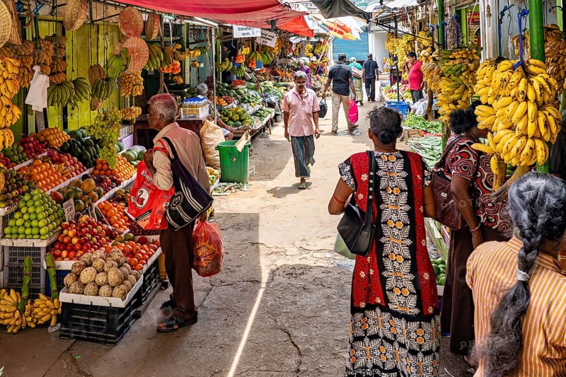 Market visitors and traders among colorful fruit and vegetables, traders in the market halls of Kandy Sri Lanka