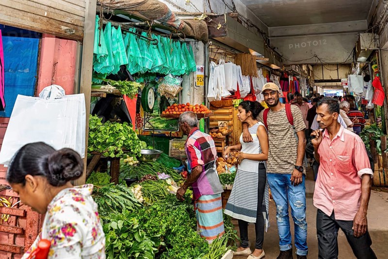 Customers and sellers in a lively vegetable stand at a market, dealers in the market halls of Kandy Sri Lanka