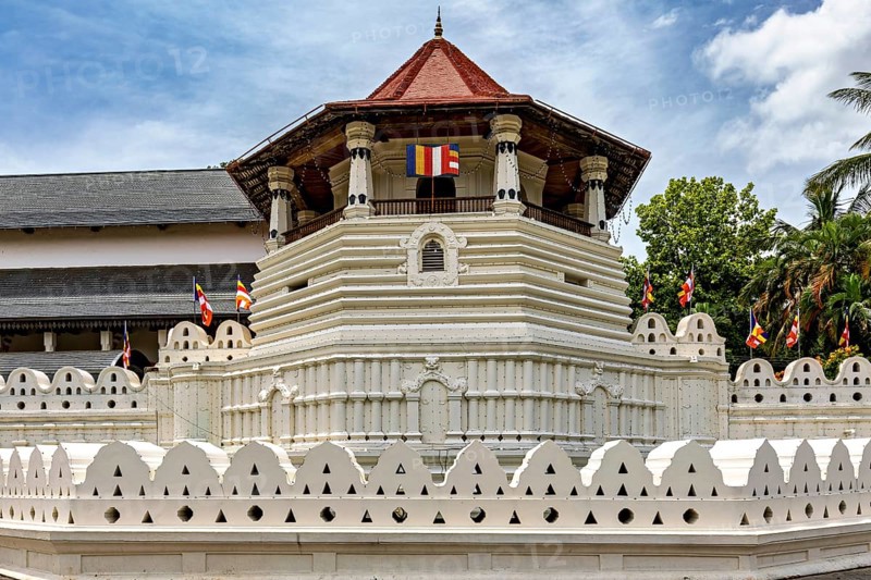 Detail of a temple with pavilion, colorful flags and white walls, The Temple of the Tooth in Kandy Sri Lanka