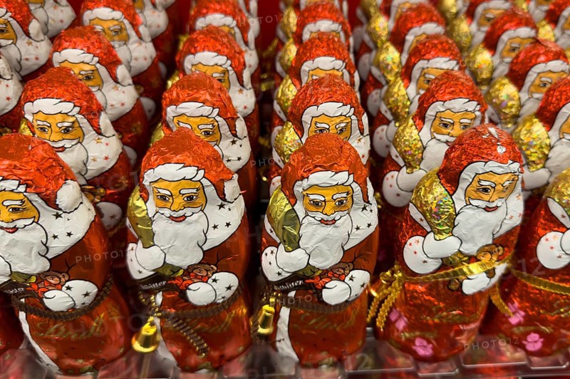 Display on the shelf of chocolate Santa Claus chocolate Santa Claus Santa Claus Santa Claus Santa Claus chocolate Santa Claus chocolate Santa Claus chocolate lice Santa Claus chocolate lice Santa Claus in color red of red staniol paper made of chocolate arranged like army of Santa Claus, Germany