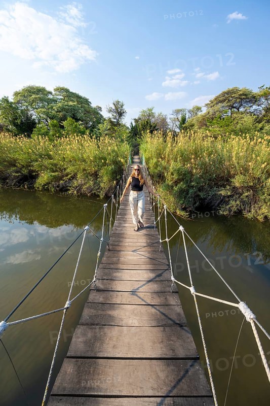 Toruist on the Kavango River, suspension bridge at Camp Kwando, Zambezi region, Caprivi Strip, Namibia
