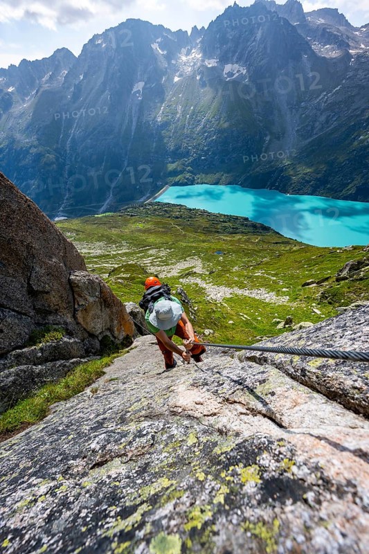 Mountaineer climbs on the secured Schijen-Zwärg via ferrata, climb to Bergseehütte, Göscheneralp in the back, Canton of Uri, Switzerland