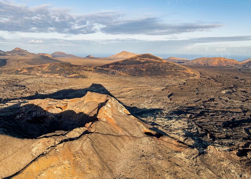 Volcán de Las Nueces volcano, picturesque volcanic landscape with volcanic craters and lava fields in morning light, Parque Natural de Los Volcanes, aerial view, Lanzarote, Canary Islands, Spain