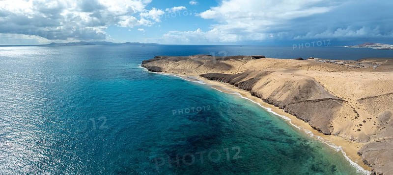 Coast with Playa Caleta del Congrio beach and blue sea, arid landscape of Los Ajaches Natural Park, aerial view, Lanzarote, Canary Islands, Spain