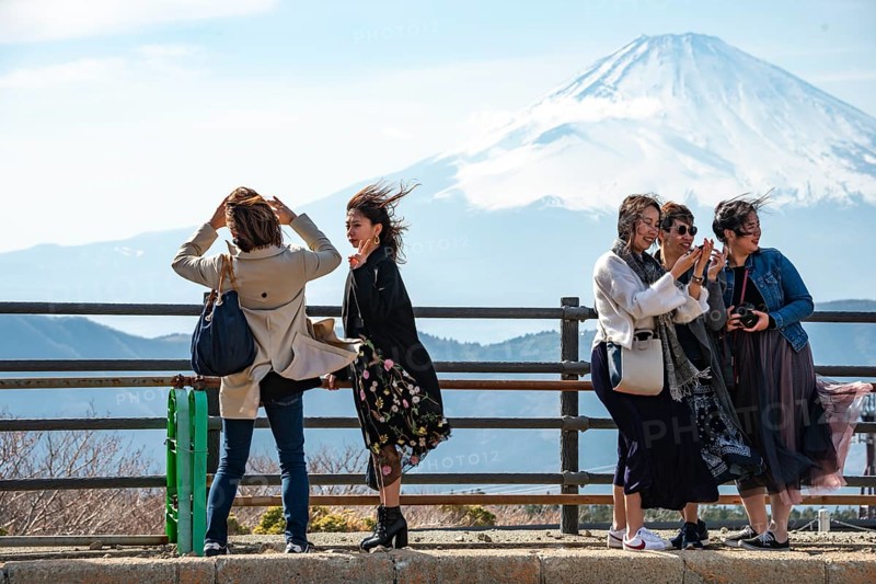 Tourists enjoy the view and take pictures, view of the snow-covered summit of Mount Fuji volcano in spring, Owakudani, Hakone, Japan