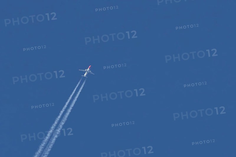 Boeing 737 jet passenger aircraft of Norwegian Air airlines flying in a blue sky with contrails or vapour trails behind, England, United Kingdom