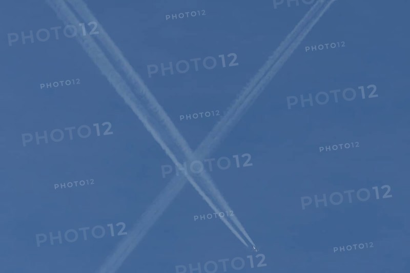Aircraft contrails or vapour trails crossing in a blue sky, England, United Kingdom