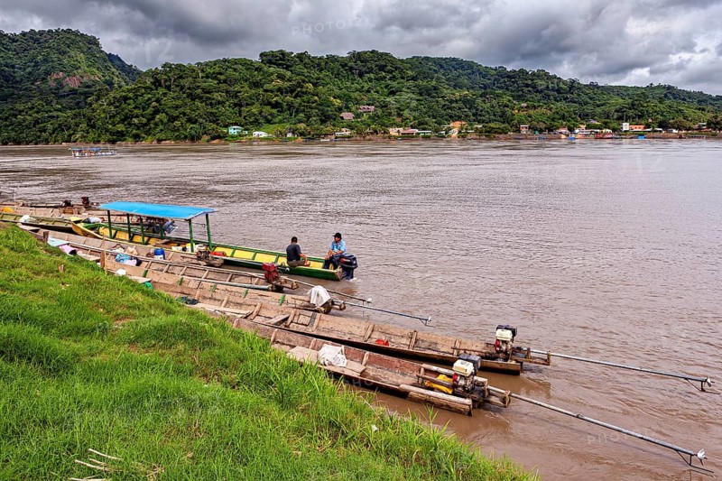 Wooden boats with motors on the banks of a river surrounded by hills, longboat on a river near Rurrenabaque in the Amazon jungle in Bolivia