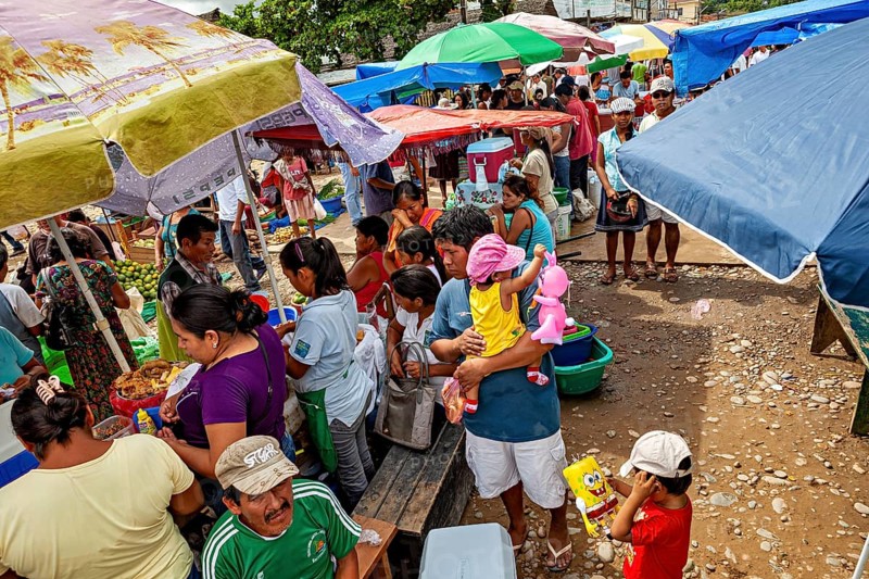 Lively market with lots of people, colorful umbrellas and a variety of goods, The Rurrenabaque market in the Amazon jungle rainforest in Bolivia
