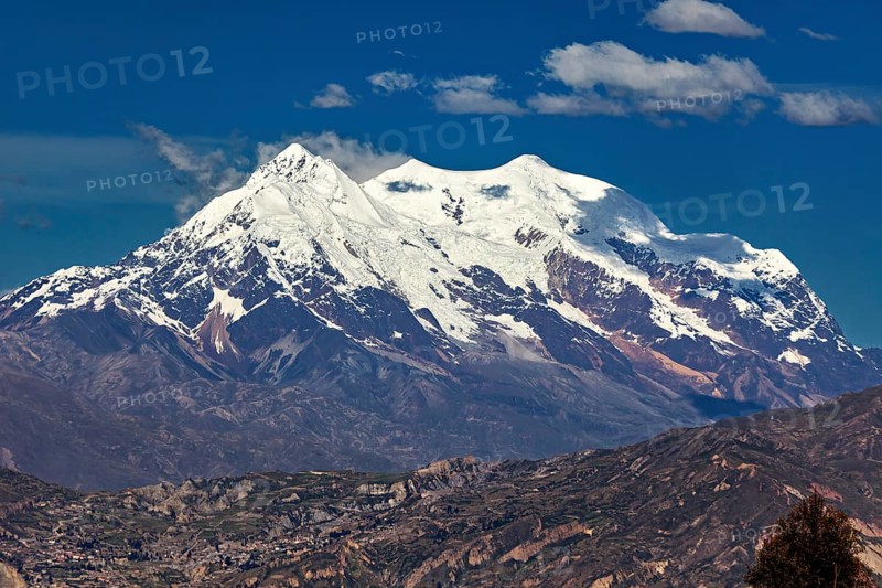 Snow-capped mountain with clear skies and rocky landscape that exudes a calm and majestic atmosphere, The snow-capped Andean peaks near La Paz in Bolivia