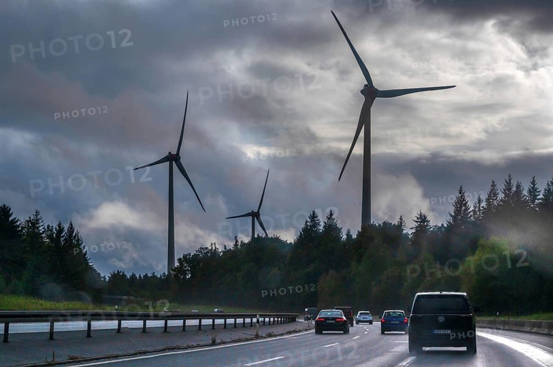 Tourist traffic on the A9 motorway during thunderstorms, wind turbines in the pine forest in the back, Bavarian Forest, Bavaria, Germany