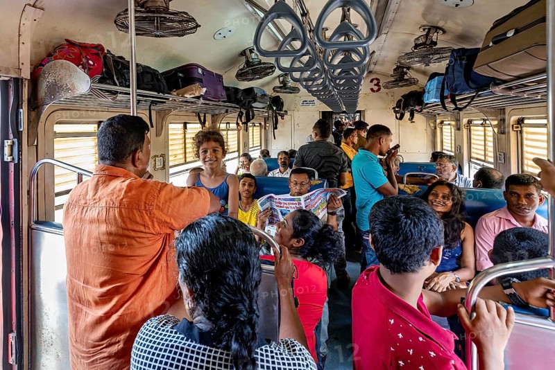 Passengers in a full train compartment, relaxed atmosphere, people talking and sitting, train ride in a wagon in Sri Lanka