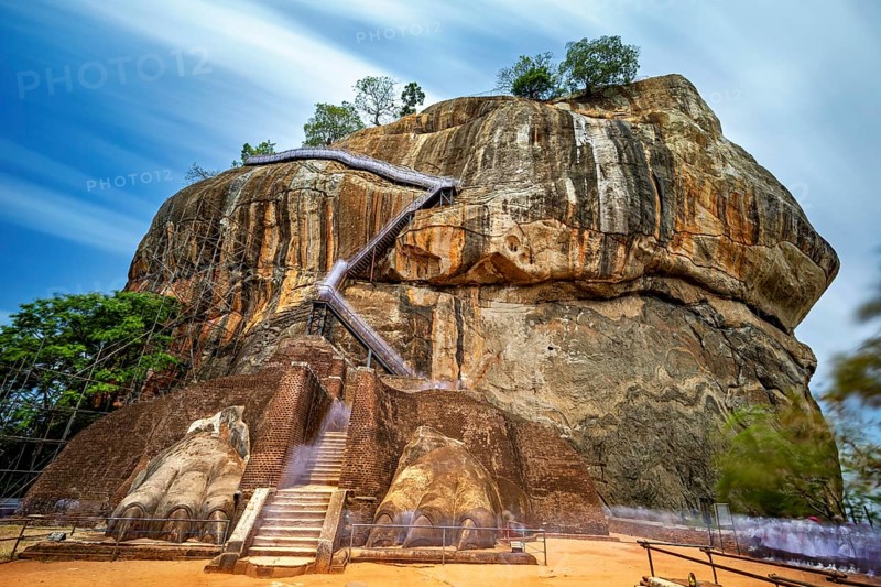 An impressive staircase on a large rock under clouds of rays, The Lion Rock near Sigiriya in Sri Lanka
