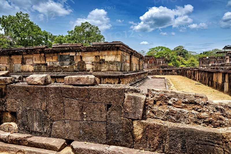 Massive ancient stone walls at a ruined site under a blue sky, The Temples of Polonnaruwa in Sri Lanka