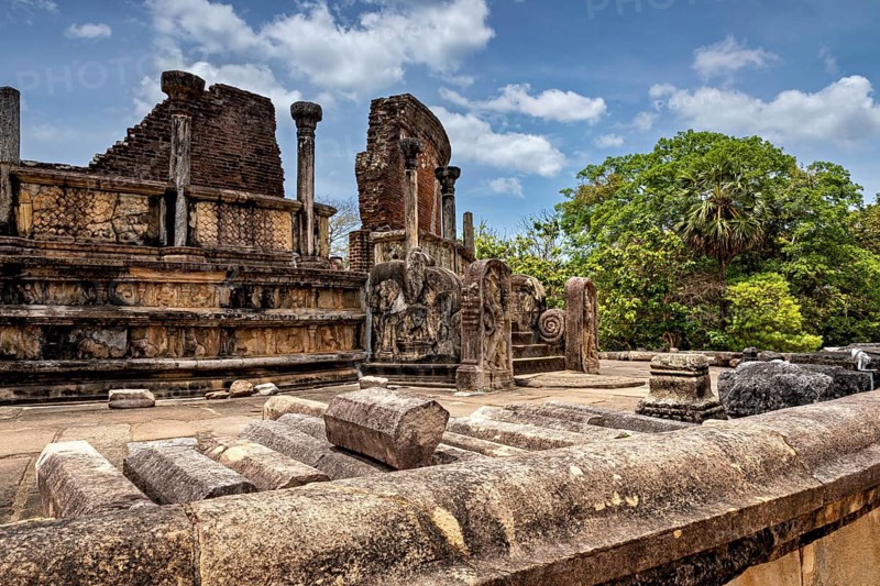 Ancient ruins with decorated stone columns and wall reliefs under a clear sky, The temples of Polonnaruwa in Sri Lanka