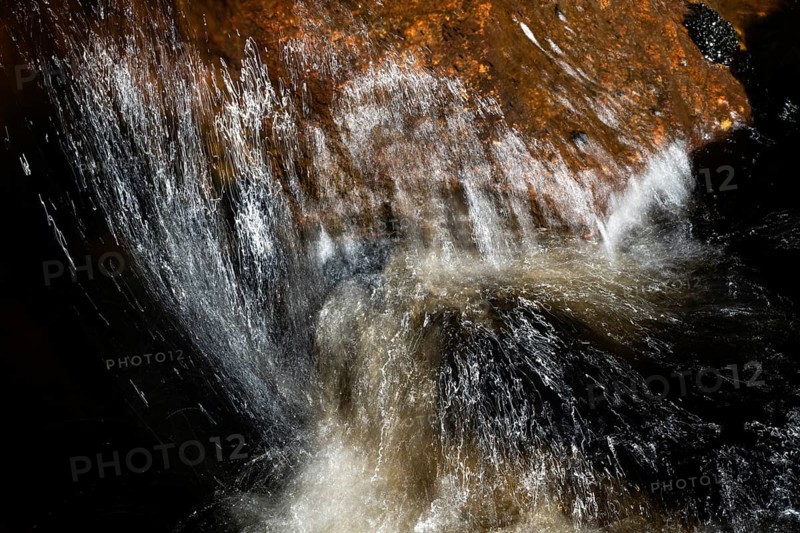 Stream flow with dark water, reflections and turbulences, long exposure, Sweden
