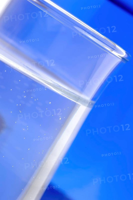 Glass with mineral water, small carbonated pearls on the edge of the glass, drinking water