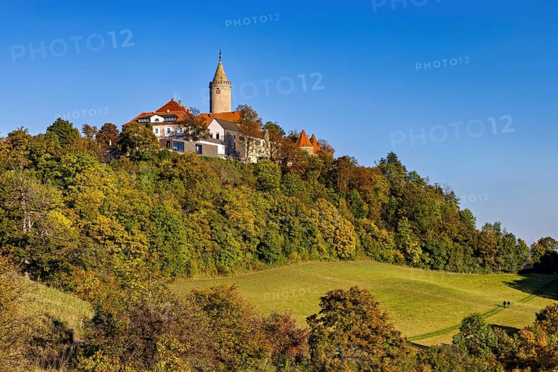A castle in a hilly wooded area, surrounded by autumn landscape and blue skies, The Leuchtenburg near Kahla in the Saale Holzlandkreis district in Thuringia