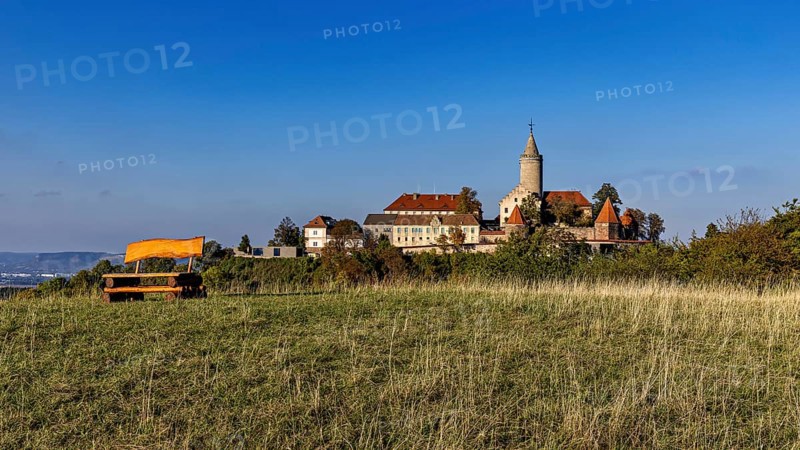 A castle on a hill with a wide meadow in the foreground and clear blue sky, The Leuchtenburg near Kahla im Saale Holzlandkreis in Thuringia