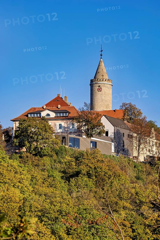 A castle with a distinctive tower, surrounded by colorful autumn trees against a clear sky, The Leuchtenburg near Kahla im Saale Holzlandkreis in Thuringia