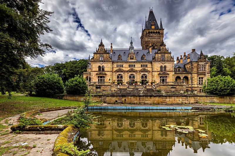 Castle with dramatic architecture reflected in a quiet pond surrounded by nature, The Hummelshain hunting lodge in Thuringia