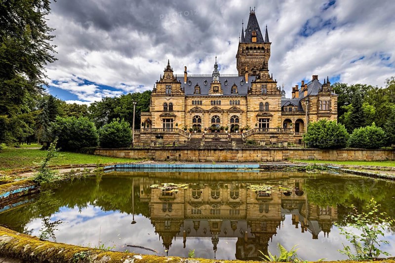 Large castle with pond reflection under a dramatic sky, The Hummelshain hunting lodge in Thuringia