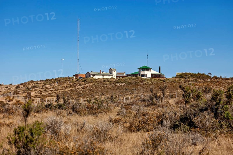 A secluded building on a hill with vegetation under a blue sky, The countryside of Peninsula Valdes in Argentina