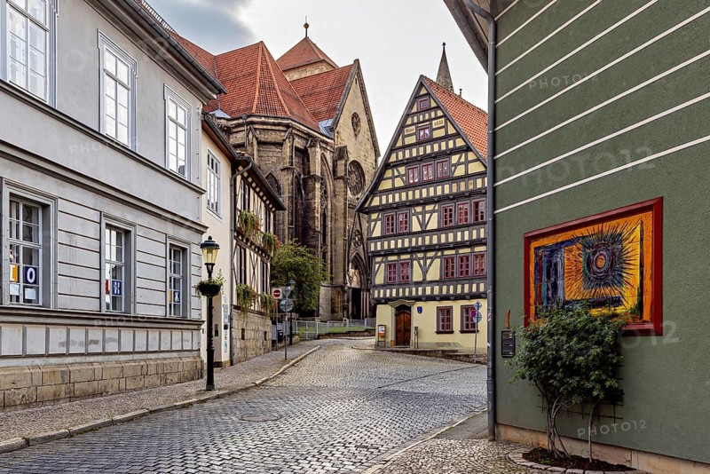 Atmospheric alley with half-timbered houses, church in the background and evening lighting, the old town of Arnstadt in Thuringia