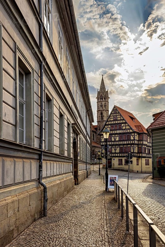 Historic city center with half-timbered houses and a church in the background under a partly cloudy sky, the old town of Arnstadt in Thuringia