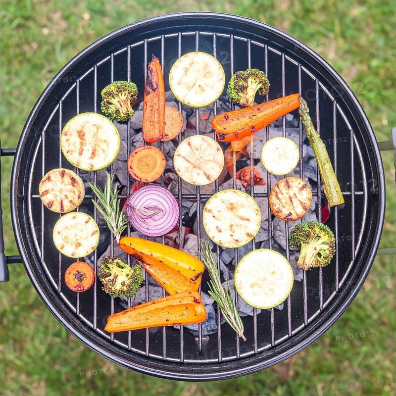Cooking vegetables on grill outdoors, healthy lifestyle with healthy food, close up of grill with blurred background, soft golden light, picnic in the green park or garden, no people, AI generated
