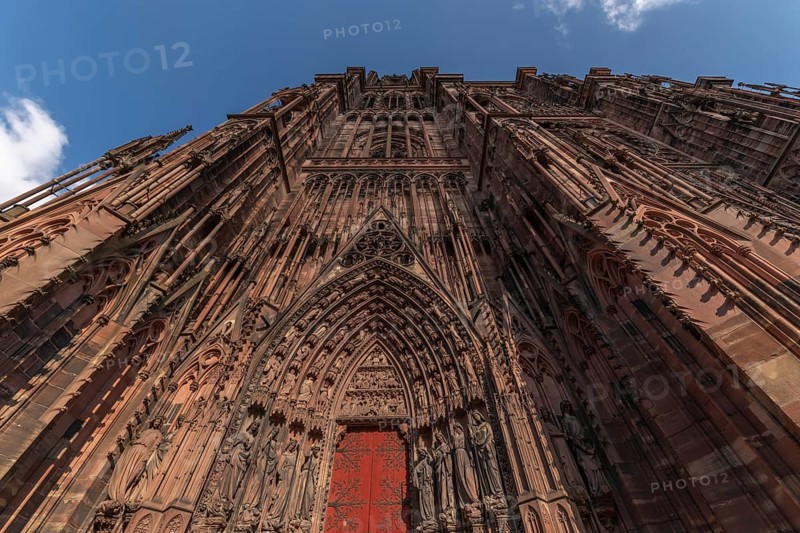 Strasbourg's Notre Dame Cathedral stands majestically there. Its magnificent architectural details are clearly visible under the blue, cloudy sky. Bas Rhin, Alsace, France