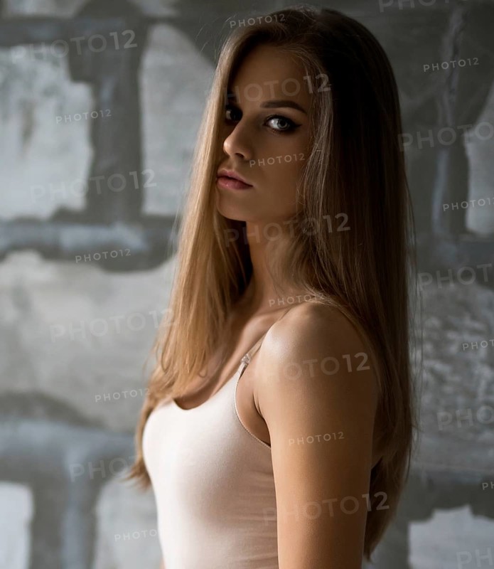 Gorgeous sexy blonde in beige body posing by a gray stone wall shot in new studio