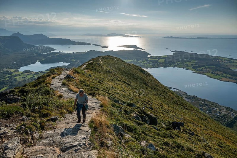 Woman with hiking poles walking up Rørsethornet stone stairs, with 3292 steps one of the longest continuous stone stairs in the world, Sherpat stairs or Midsund stairs or Midsundtrappene, Rørsethornet hike, Otroya or Otrøya island, Møre og Romsdal, Norway